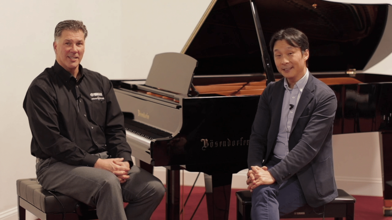 two guys sitting in front of piano